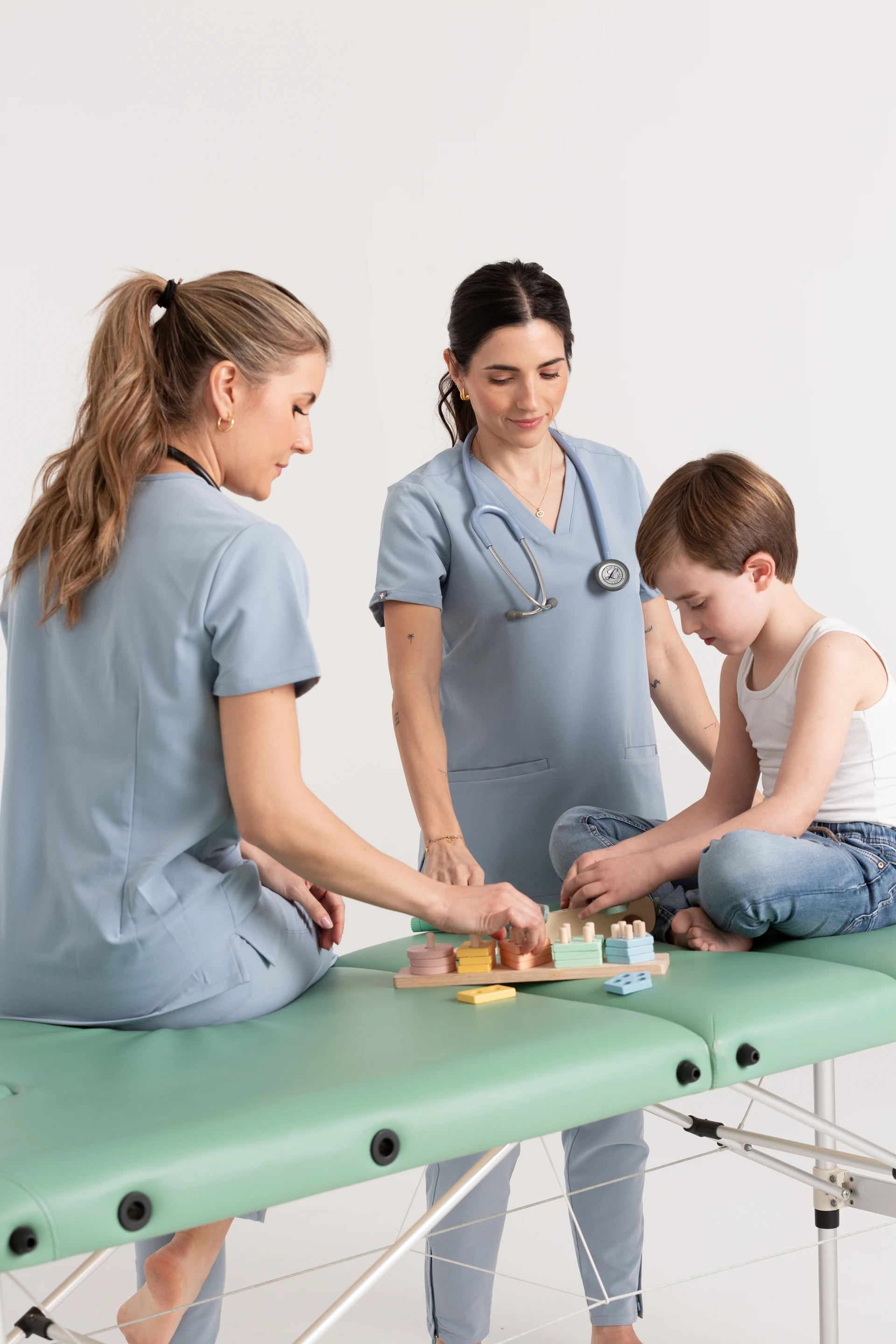Ángela y María acompañando a un niño en la consulta de AMAR Pediatría